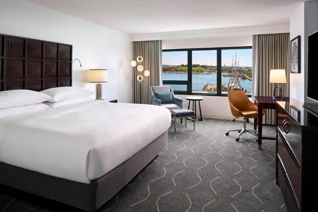 een hotelkamer met een groot bed, een bureau en een stoel bij Renaissance Baltimore Harborplace Hotel in Baltimore