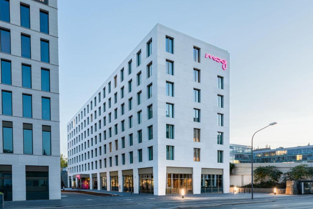 a white building with a hotel sign on it at Moxy Wuerzburg in Würzburg