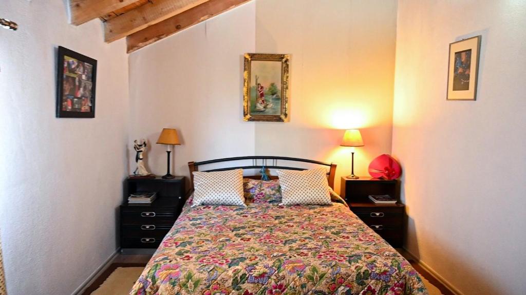 a bedroom with a bed and two night stands and two lamps at Vila Topalli in Pogradec