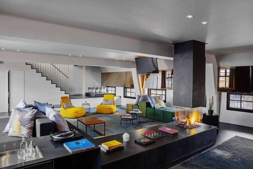 a living room with yellow and green furniture and a fireplace at W Amsterdam in Amsterdam