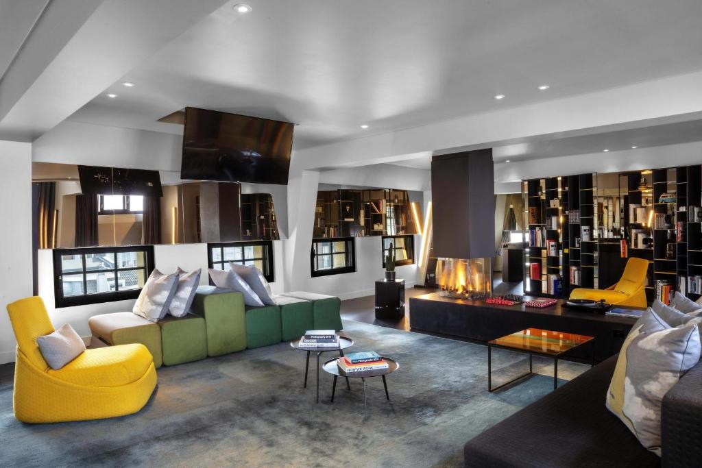 a living room with a green couch and yellow chairs at W Amsterdam in Amsterdam