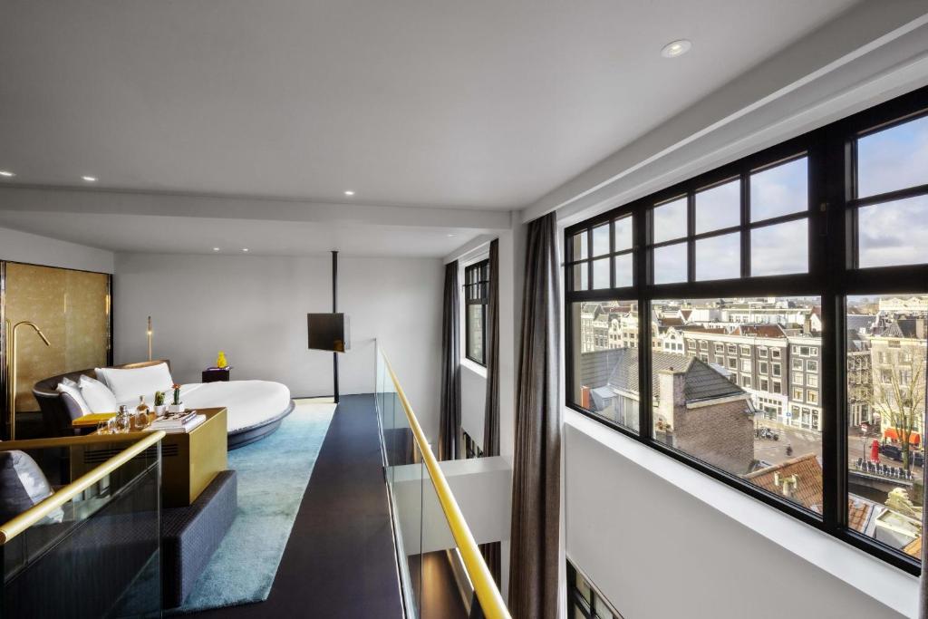 a bedroom with a bed and a large window at W Amsterdam in Amsterdam