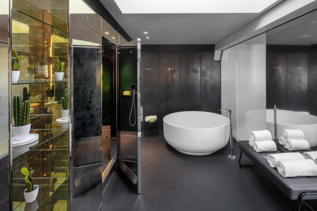 a bathroom with a large tub and a shower at W Amsterdam in Amsterdam