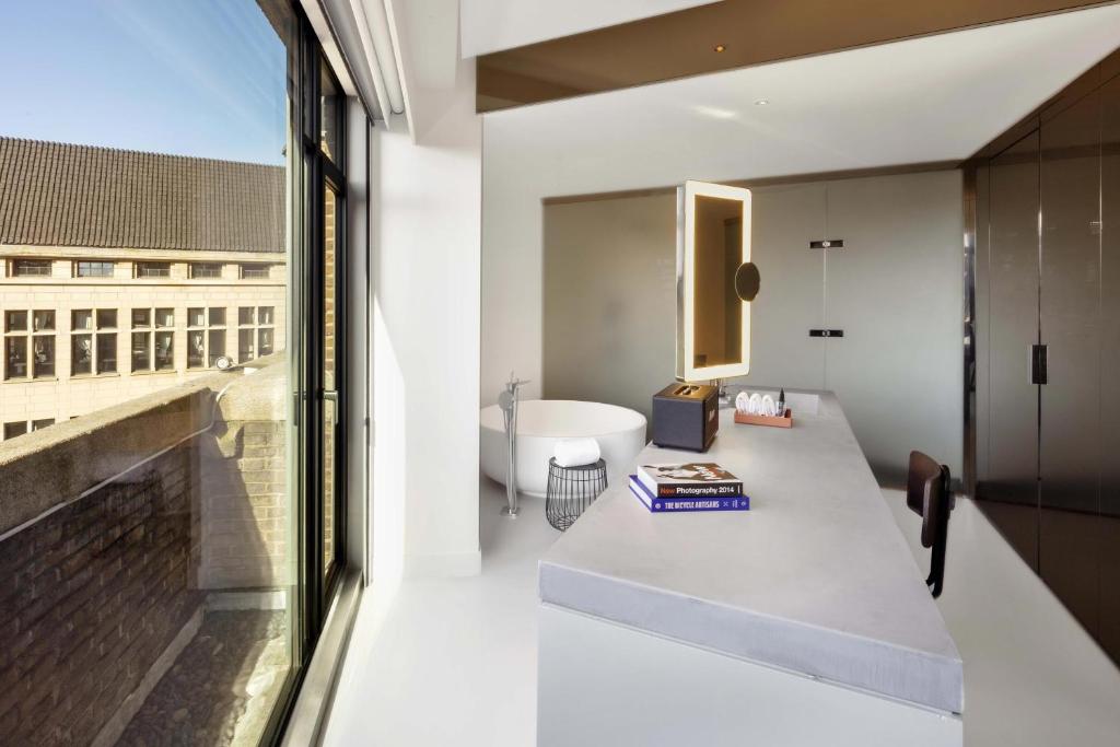 a bathroom with a tub and a toilet and a sink at W Amsterdam in Amsterdam