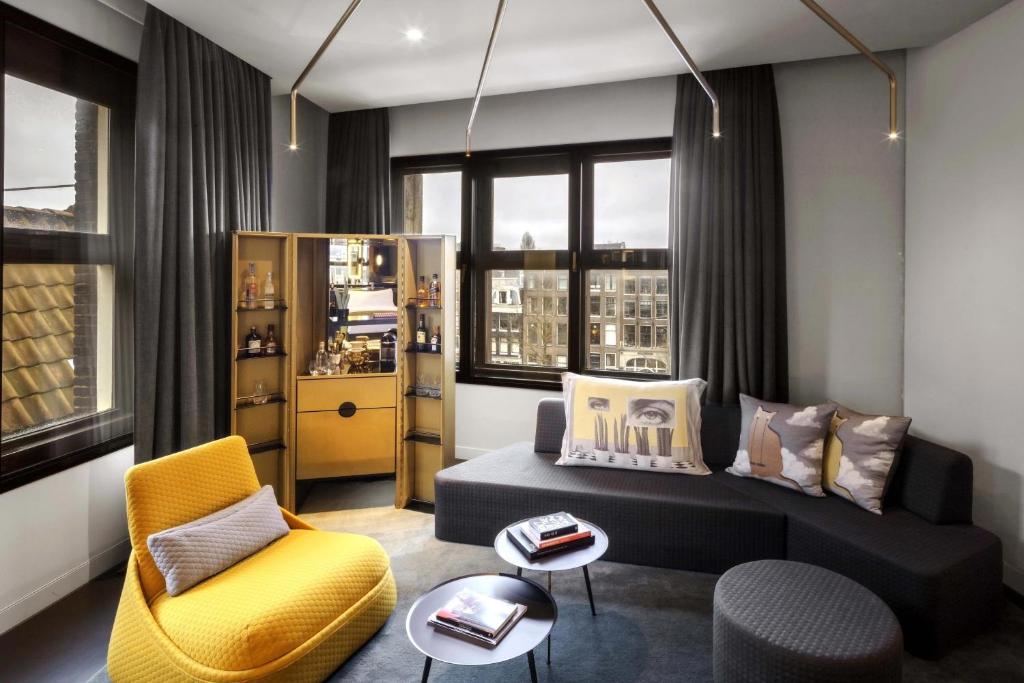 a living room with a couch and a chair at W Amsterdam in Amsterdam