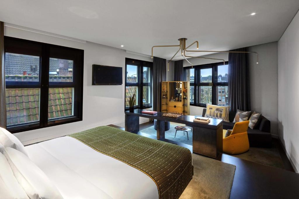 a bedroom with a bed and a desk in a room at W Amsterdam in Amsterdam