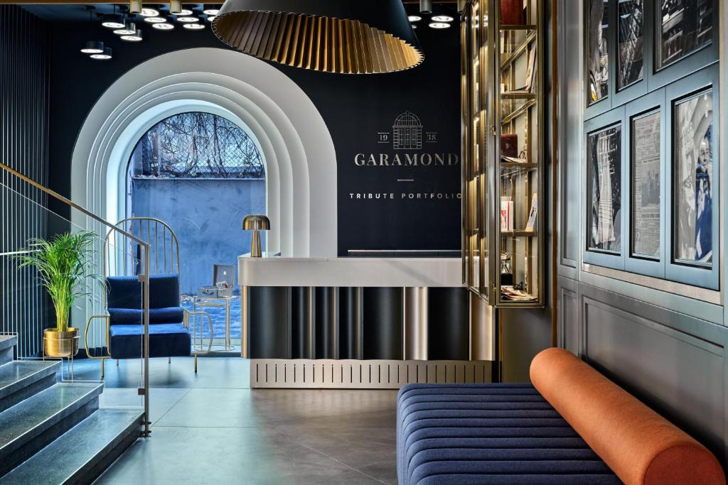 a lobby with a blue couch and a staircase at Garamond a Tribute Portfolio Hotel in Kraków