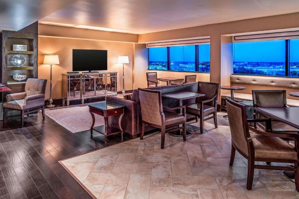 a dining room with tables and chairs and a flat screen tv at Sheraton North Houston at George Bush Intercontinental in Houston