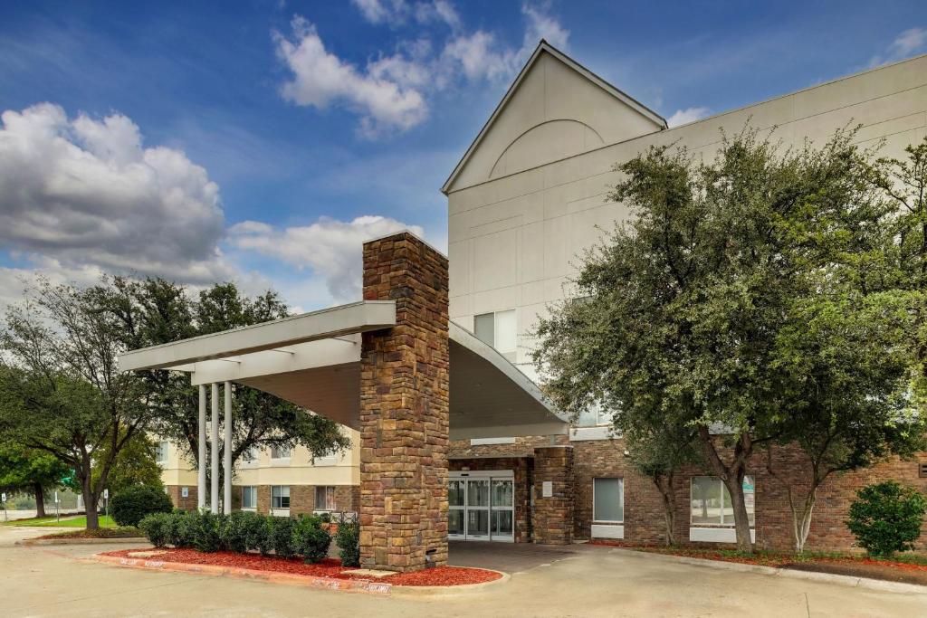 a large white building with a brick pillar at Fairfield Inn by Marriott Las Colinas in Irving