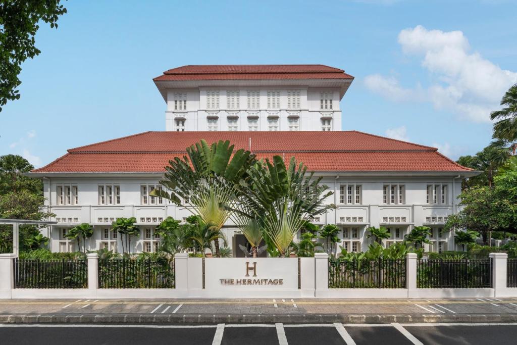 um grande edifício branco com um telhado vermelho em The Hermitage, A Tribute Portfolio Hotel, Jakarta em Jakarta