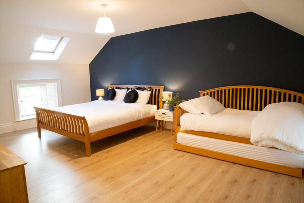 a bedroom with two beds and a blue wall at Prizon House Balla in Mayo