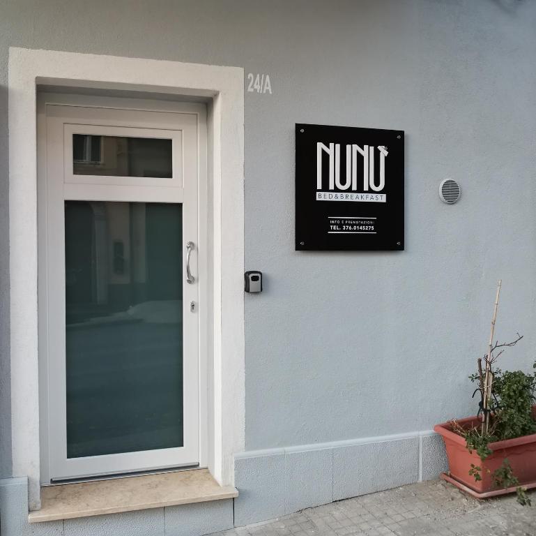 eine Tür mit einem Schild an der Seite eines Gebäudes in der Unterkunft Nunù Bed and Breakfast in Acri