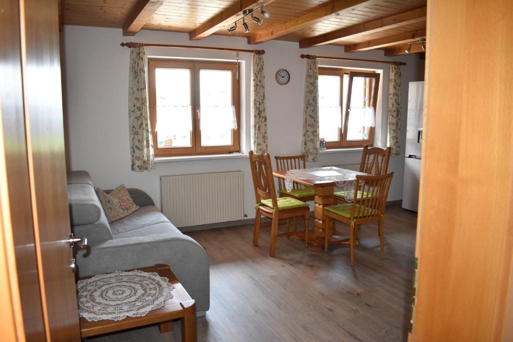 ein Wohnzimmer mit einem Sofa, einem Tisch und Stühlen in der Unterkunft Ferienwohnung in Fraxern