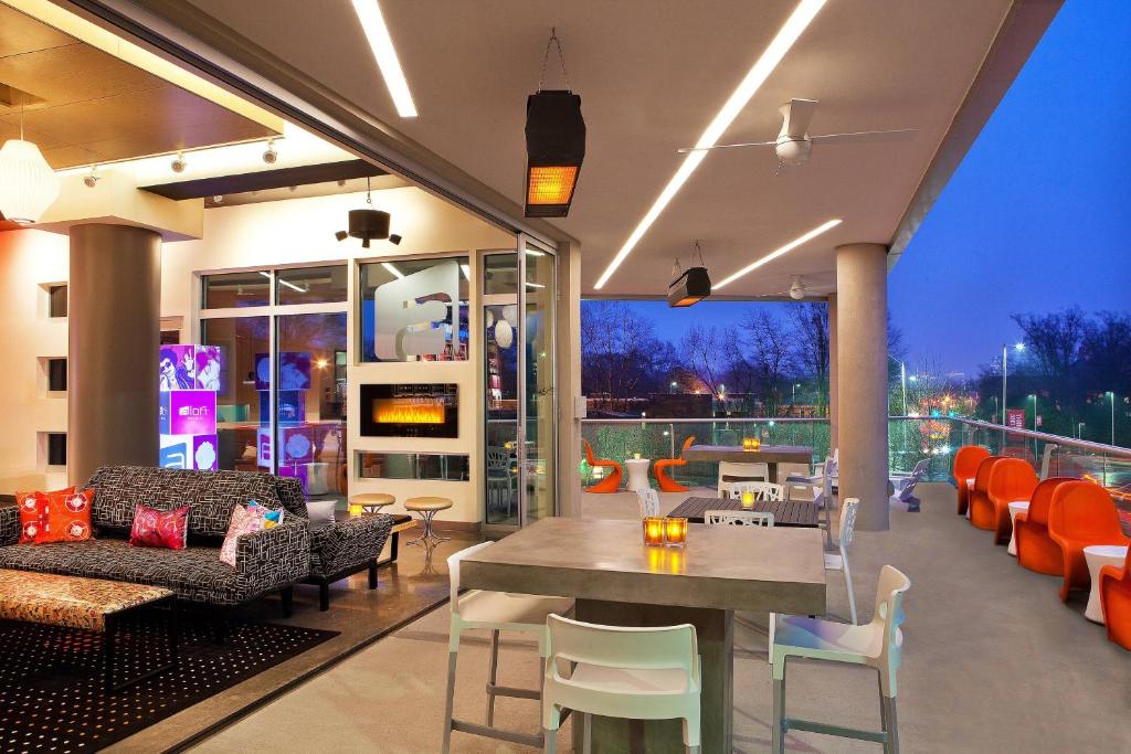 a living room with a table and chairs at Aloft Raleigh in Raleigh