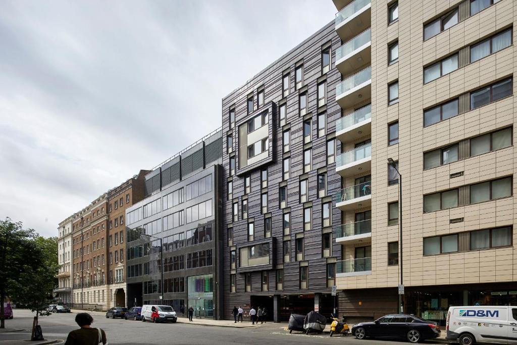 a large building on a city street with parked cars at Goldsmid House, Victoria in London