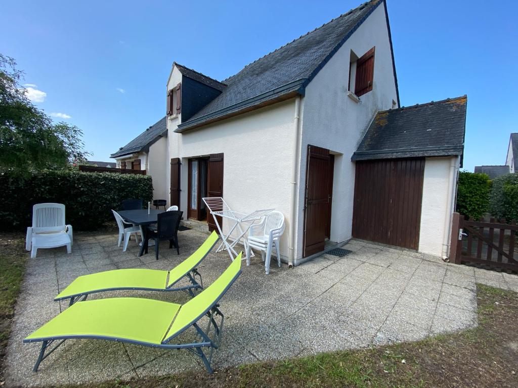 a patio with chairs and a table and a house at Le Clos des Dunes, maison à Erdeven in Erdeven