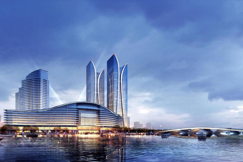 eine Gruppe großer Gebäude in einer Stadt mit Wasser in der Unterkunft Sheraton Rizhao Hotel in Rizhao