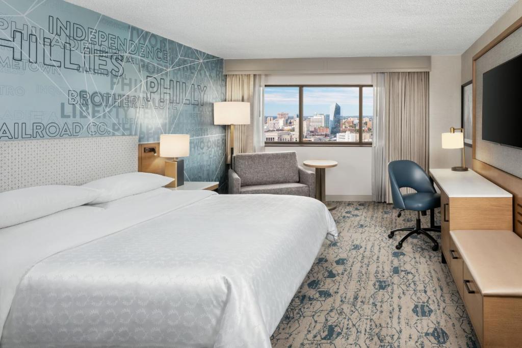 una camera d'albergo con letto, scrivania e sedia di Sheraton Philadelphia Downtown a Philadelphia