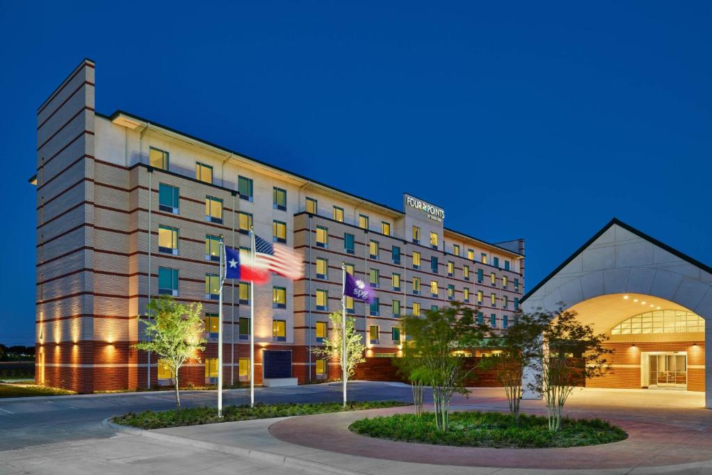 a hotel building with flags in front of it at Four Points by Sheraton Dallas Fort Worth Airport North in Coppell