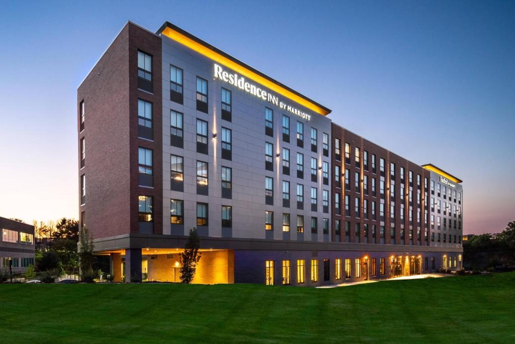 un grand bâtiment avec une pelouse devant lui dans l'établissement Residence Inn by Marriott Boston Waltham, à Waltham