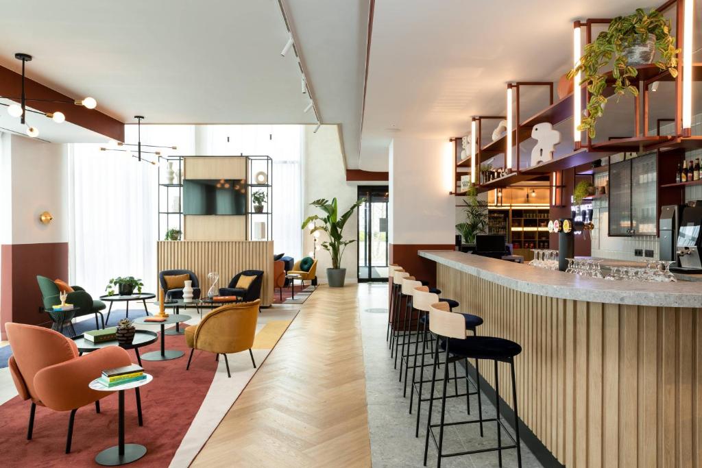 eine Bar in einem Restaurant mit Stühlen und Tischen in der Unterkunft Residence Inn by Marriott Brussels Airport in Diegem
