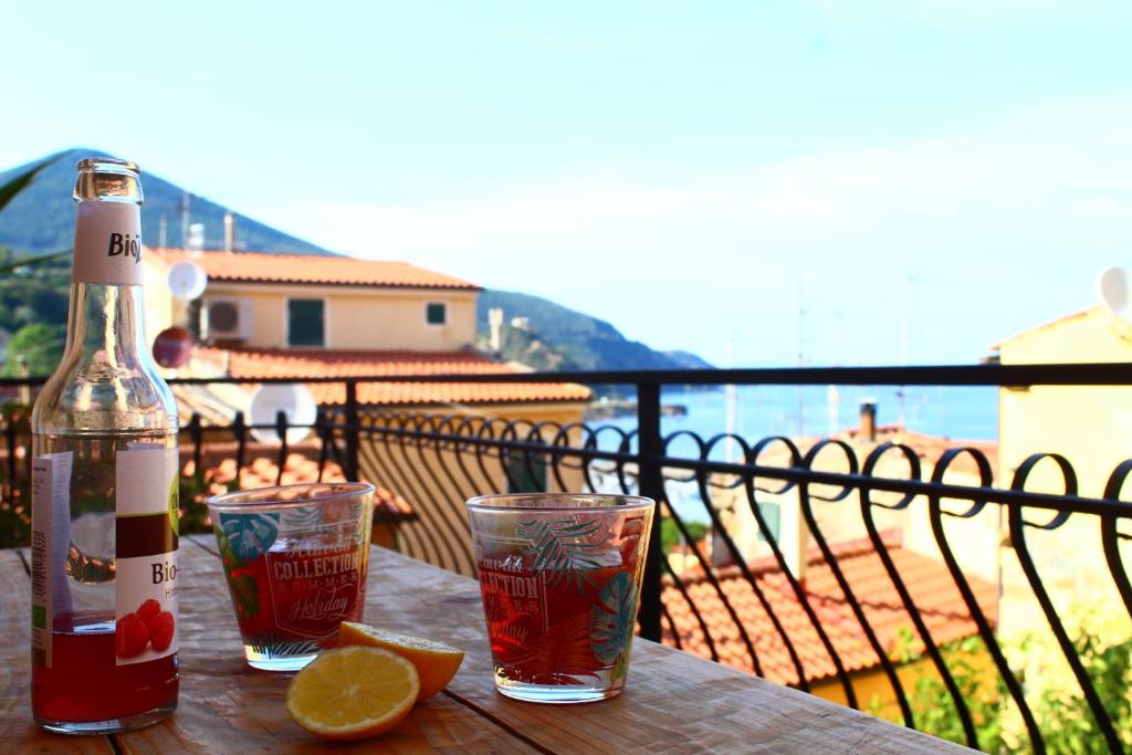 a bottle of wine and two glasses on a table at La terrazza sugli aranci in Rio Marina