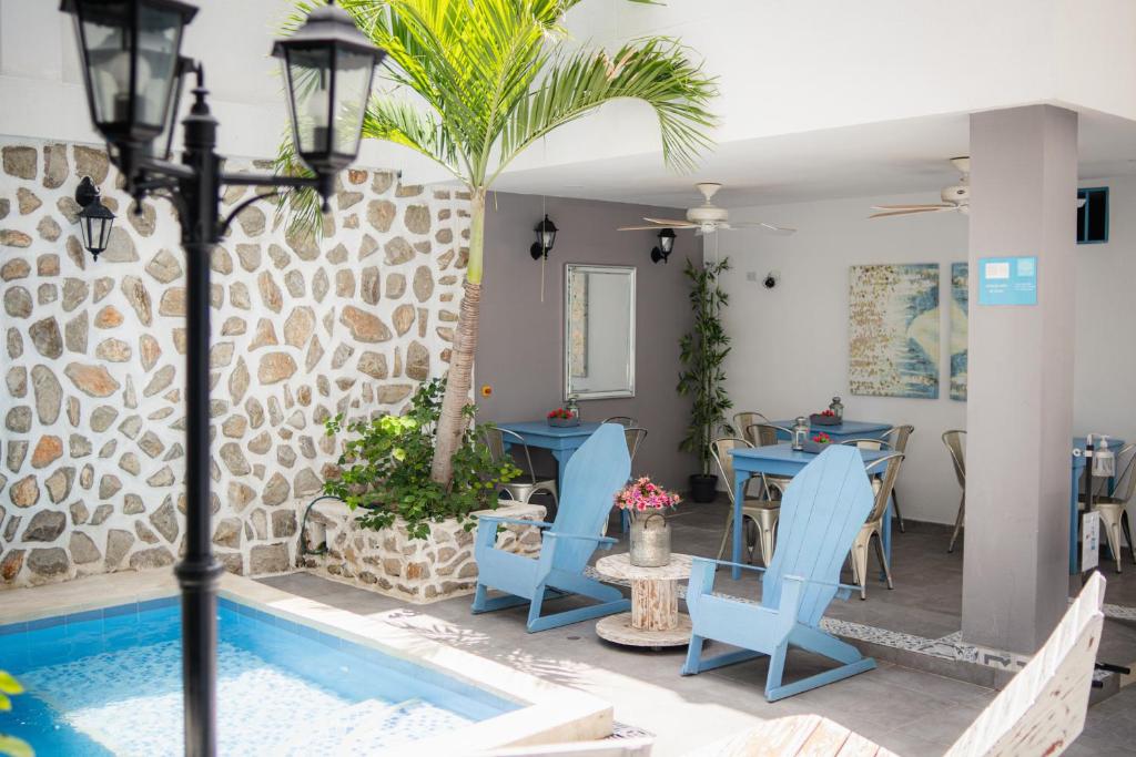 a patio with blue chairs and a swimming pool at Hotel ADAZ Mediterráneo in Santa Marta