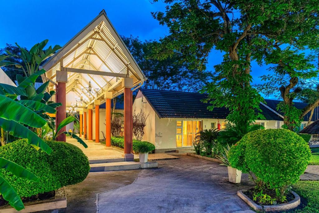 een huis met een veranda met bomen en struiken bij Protea Hotel by Marriott Zambezi River Lodge in Katima Mulilo