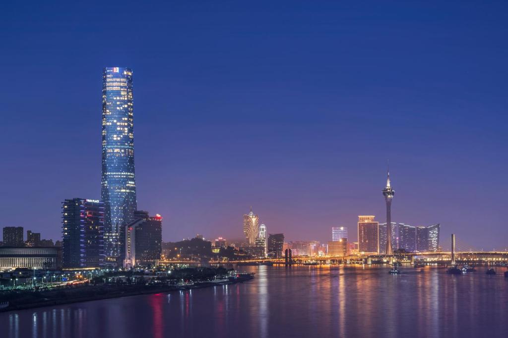 een skyline van de stad 's nachts met een rivier en gebouwen bij The St. Regis Zhuhai in Zhuhai