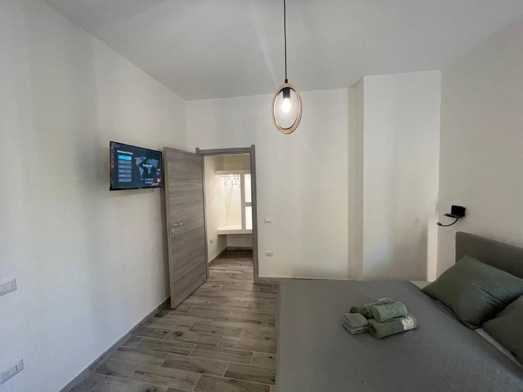 Cette chambre comprend un lit et une télévision murale. dans l'établissement Rooms Via XX Settembre, à Capoterra