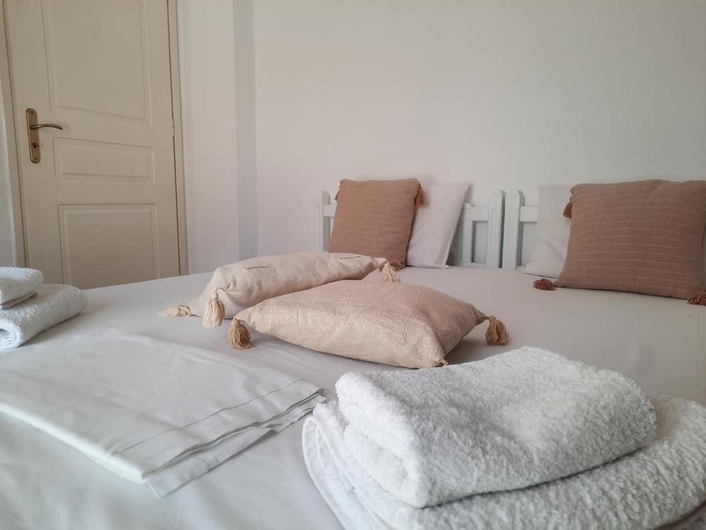 two pillows and towels on a white bed at Maria's Village Home in Glinado Naxos