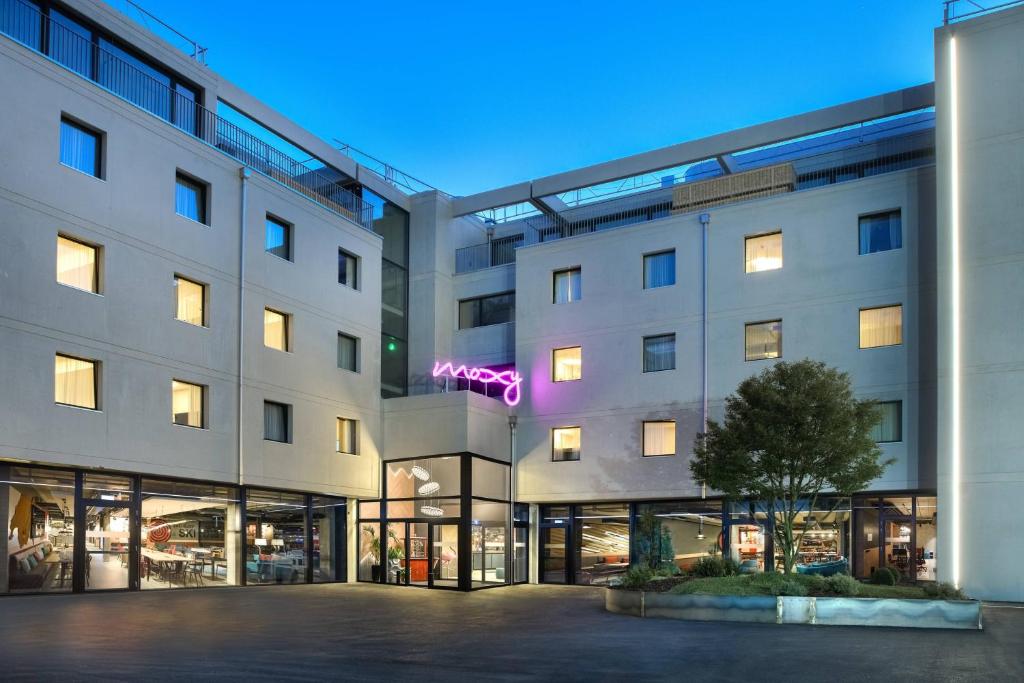 un edificio de apartamentos con un letrero de neón en él en Moxy Sion, en Sion