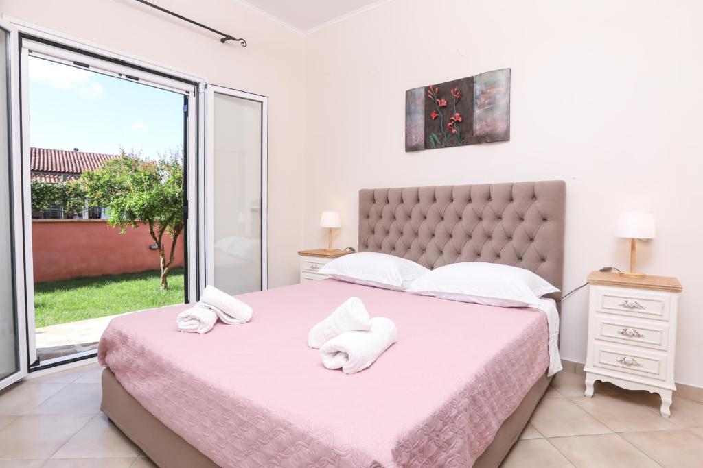 una camera da letto con un grande letto con asciugamani di Renos House by Corfu Escapes a Vragkaniótika