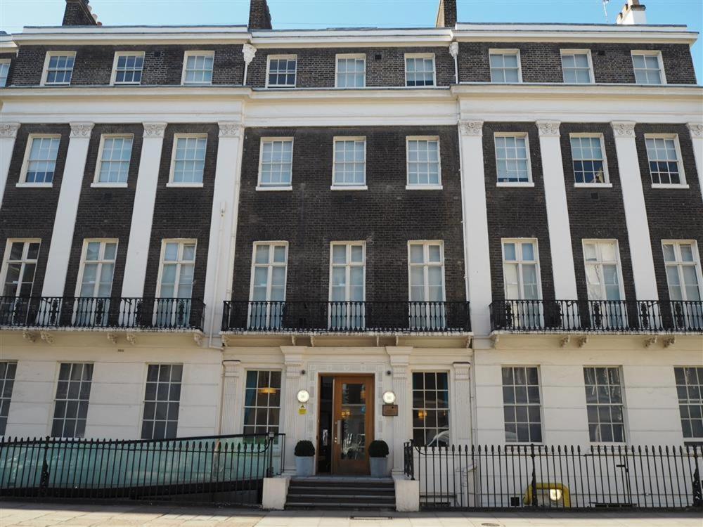 ロンドンにあるJohn Adams Hallの玄関付きの茶色と白の大きな建物