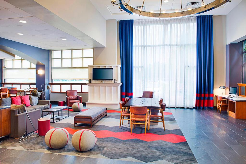 a living room with a tv and a couch and chairs at Four Points by Sheraton Philadelphia Airport in Philadelphia