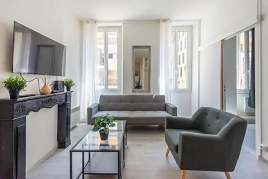 een woonkamer met een bank en een open haard bij T2 Appartement lumineux à la Joliette in Marseille