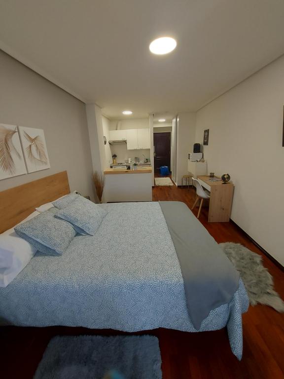 1 dormitorio con 1 cama grande con almohadas azules en La Cabaña en Vigo