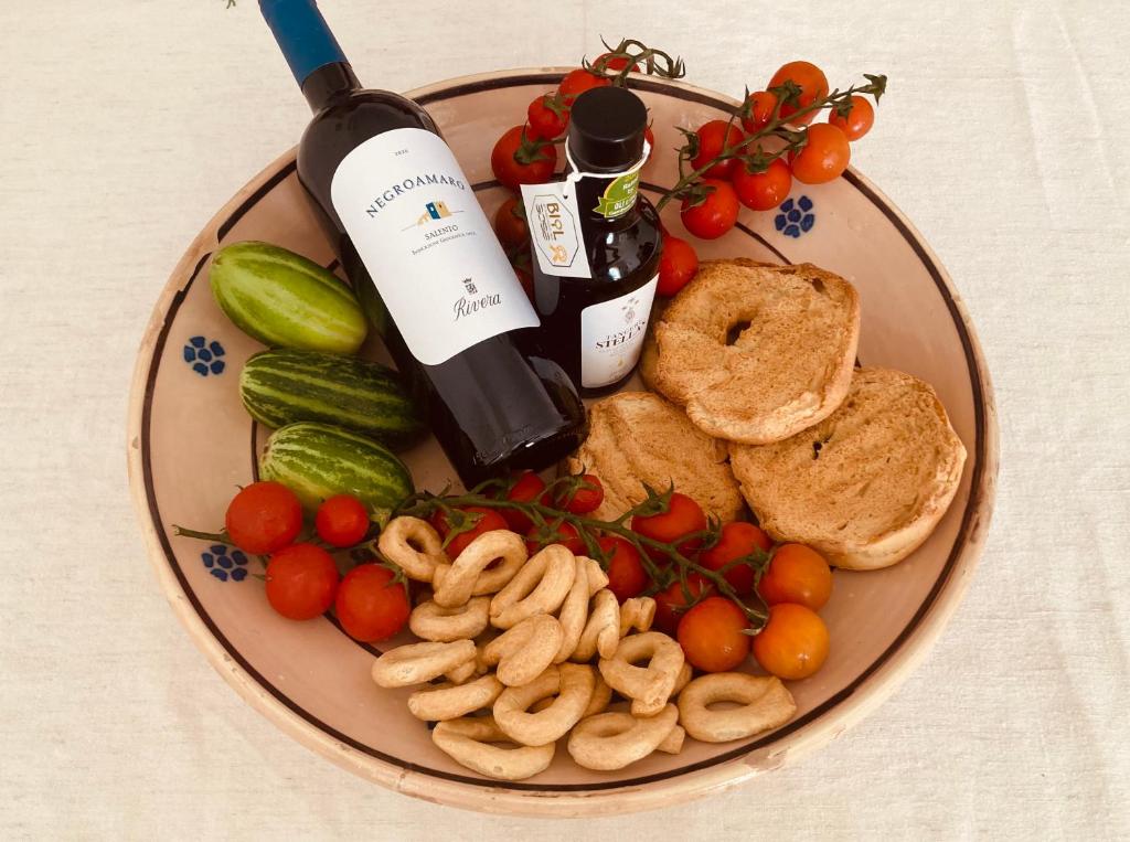 a plate of food with a bottle of wine and vegetables at La Racioppola in Ostuni