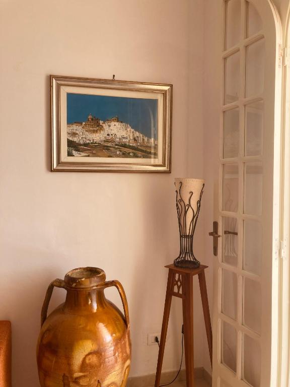 a vase sitting on a stool next to a painting on the wall at La Racioppola in Ostuni