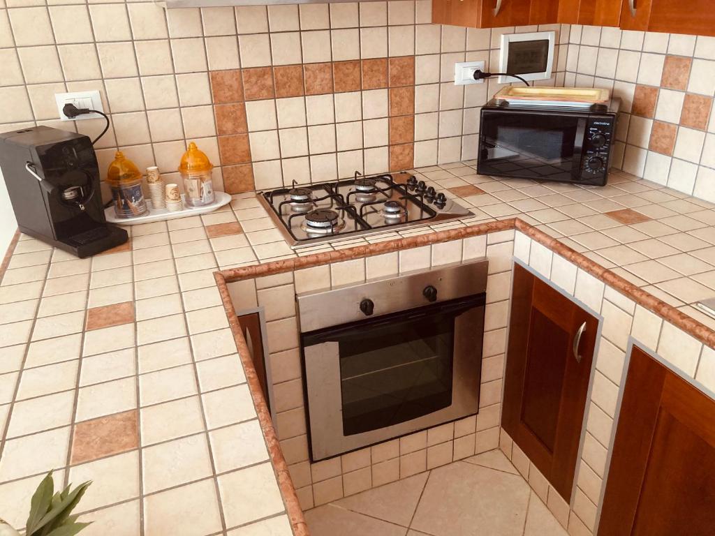 a kitchen with a stove top oven and a microwave at La Racioppola in Ostuni
