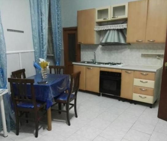 uma cozinha com uma mesa com uma toalha de mesa azul em La casa di Eleonora em Nápoles