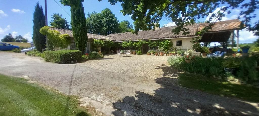 a house with a gravel driveway in front of it at Las Cafourques Chambre d'Hotes in Ségalas