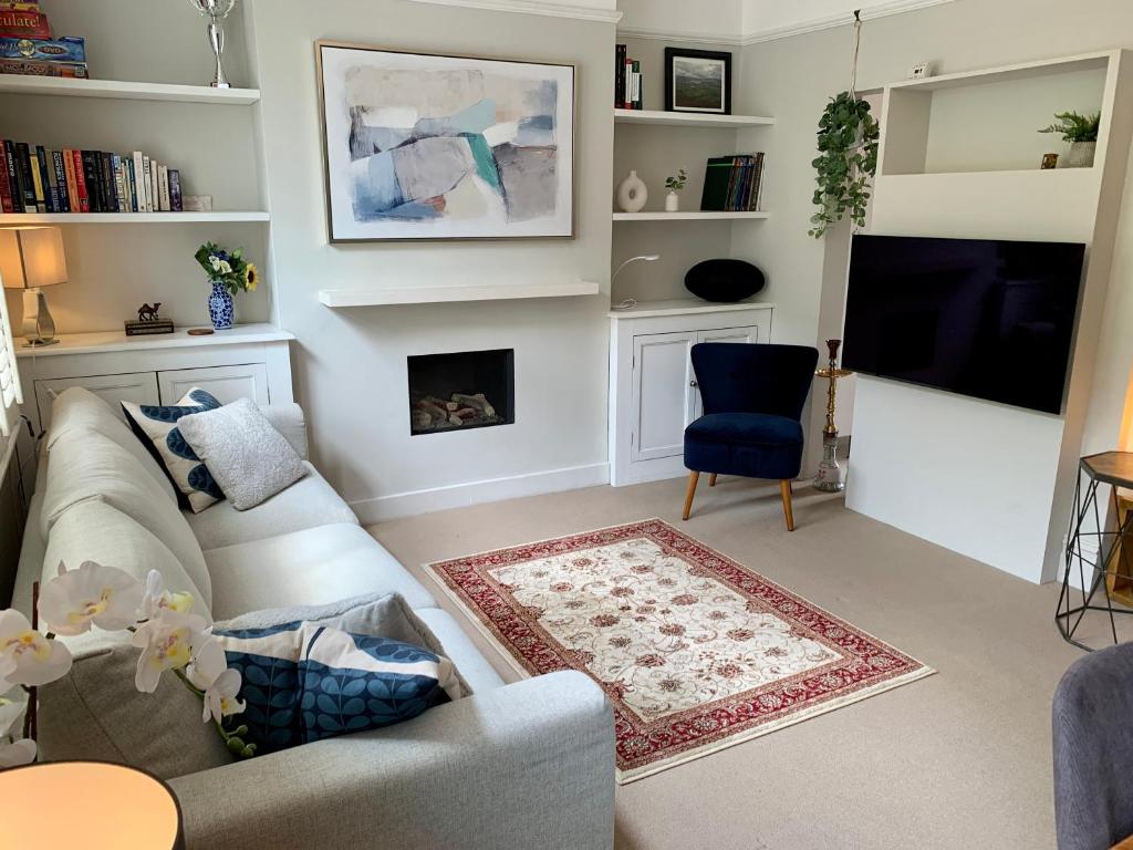 uma sala de estar com um sofá e uma televisão em Lovely newly refurbished apartment in Battersea em Londres