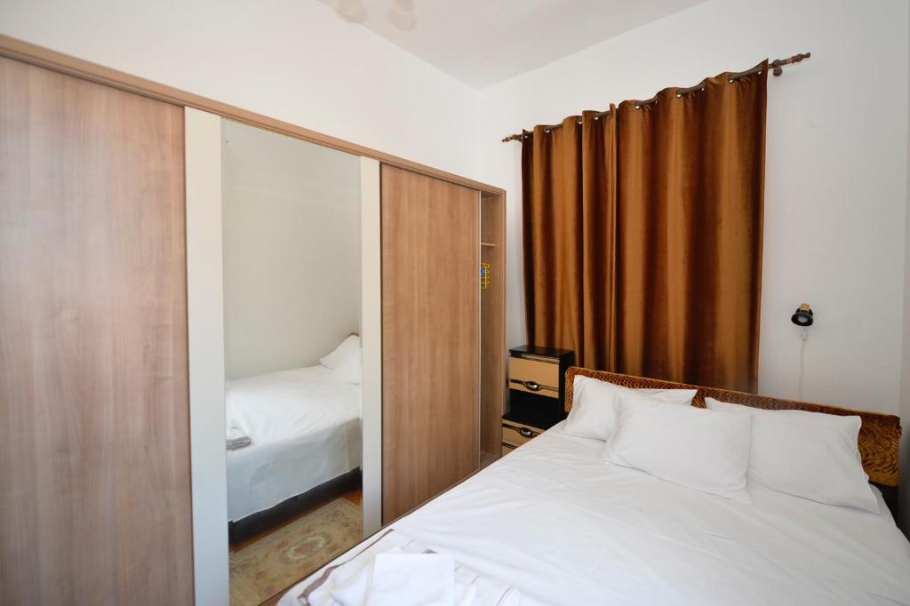 Dormitorio pequeño con cama y espejo en City View Apartment, en Kotor