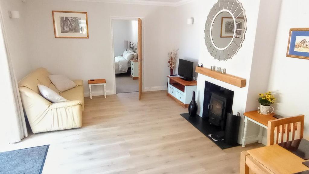 uma sala de estar com um sofá e uma lareira em Oakcroft em Sidmouth