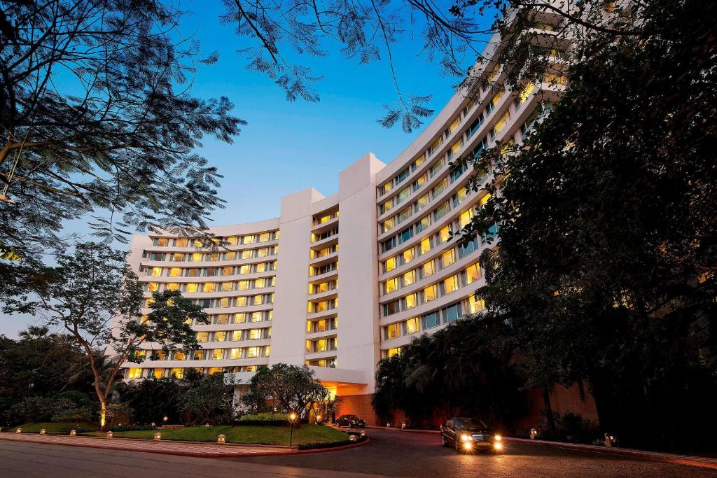 孟買的住宿－Marriott Executive Apartment - Lakeside Chalet, Mumbai，一辆汽车驶过白色的大建筑