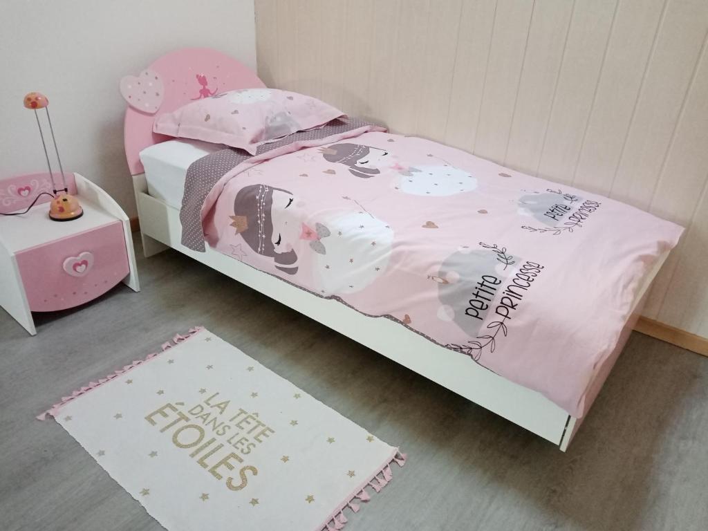 a childs bedroom with a bed with a hello kitty blanket at Le passage de Gardie 