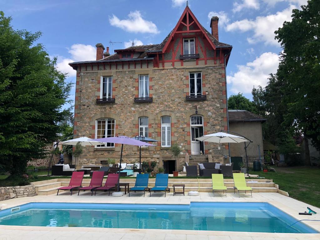 a house with chairs and a pool in front of it at Maison de la Comtesse in Cosne-dʼAllier