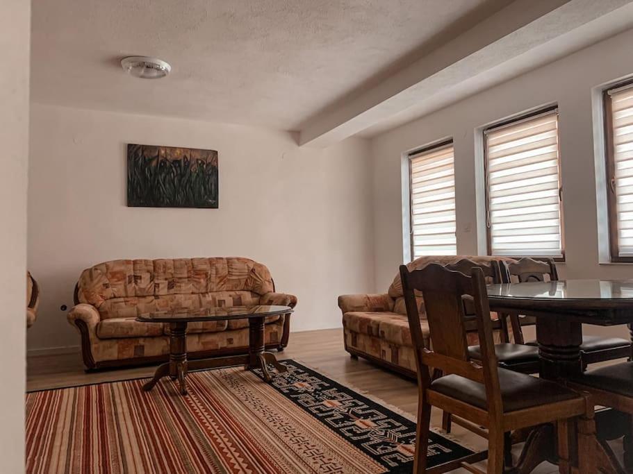 un soggiorno con divano e tavolo di Dardania Apartments a Pejë