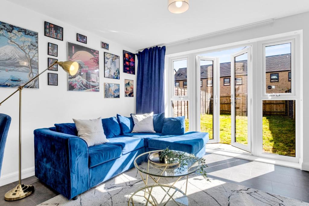 ein blaues Sofa im Wohnzimmer mit Fenstern in der Unterkunft City Centre 3 Bedroom House - Family & Business in Birmingham